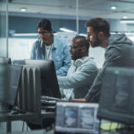 3 people in a data center staring at a computer