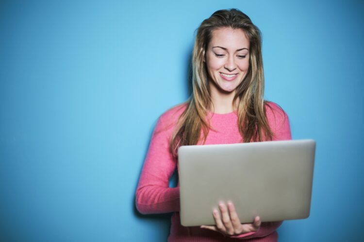 Woman on computer with a blue background